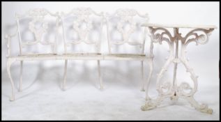 A vintage 20th century cast metal garden three seater / seat bench and matching table having a