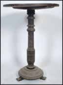 A 19th century Victorian oak wine occasional table raised on three bun feet with turned circular