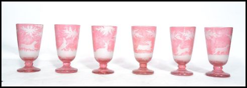 A set of six 19th century hunting theme Victorian Bohemian cut glass goblets. The cranberry glass