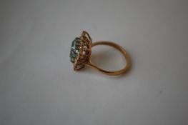 A hallmarked 9ct gold cluster ring set with a sentral emerald cut blue stone surrounded by a white