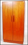A G-Plan 20th century teak wood double door wardrobe in the ' Kelso ' pattern. Raised on plinth base
