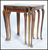A 20th century trio nest of tables being Japanned and lacquered with gilt borders depicting domestic