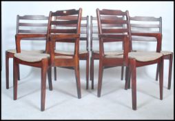 A set of 20th century retro teak wood stained dining chairs complete with the 2 carvers. Railed