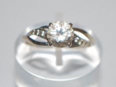 A hallmarked 9ct white gold ring set with a central round cut CZ having CZ pierced shoulders.