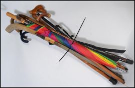 A collection of vintage 20th century walking sticks and umbrellas to include a knobkerrie and hockey