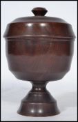AN 18th century Georgian treen turned wood goblet and over made of laburnum having a finial top lid.