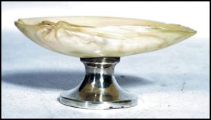 A silver hallmarked and mother of pearl table salt raised on a circular silver base with mother of