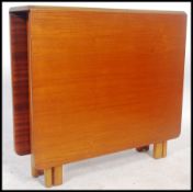 G plan - A 1970's teak wood drop leaf dining table raised on pierced legs with a scissor gate leg