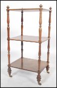 A Victorian walnut 3 tier etargere / whatnot being raised on cup and cover legs with brass cap