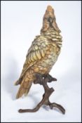 A vintage 20th century cold painted Austrian bronze figurine of a parrot resting on a branch