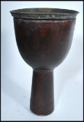 A 20th century side table in the form of a tribal drum with a brass Anglo Indian top. Measures