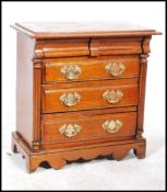 A 19th century walnut miniature chest of drawers apprentice piece having three drawers with brass