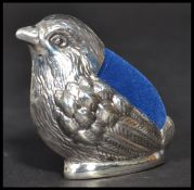 A sterling silver pin cushion in the form of a bird with blue baize cushion atop. In the manner of