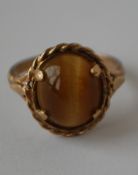 A hallmarked 9ct gold ring set with a tigers eye cabochon.  Hallmarked London.  Size L. Weight 3.3g.