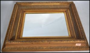 An early 20th century wall mirror having an ornate gilt stepped frame. The central bevelled glass