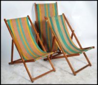Hatherley - A group of three retro 1960's folding teak deck chairs each having stripped material