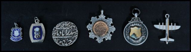 A group of silver charms and fobs to include two hallmarked silver and gold fobs and some small
