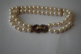 An 18ct gold diamond and sapphire pearl bracelet having a blue sapphire and diamond set stylised