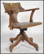 An early 20th century / circa 1920's industrial mahogany swivel office desk chair having a fan