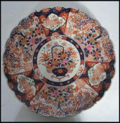 A 19th century Japanese Imari charger of large form having a scalloped edge. Hand painted in the