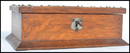 A 1920's oak table lidded cigarette box of rectangular form having pressed metal decoration and a