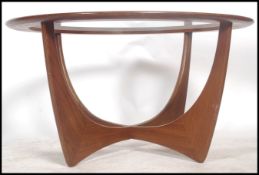 A 1970's G-plan teak model 8040 'Astro' coffee table, with inset circular glass top over stylized