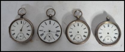 A group of four vintage early 20th century silver pocket watches all having white enamel faces
