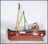 A vintage 20th century scratch built model of a fishing trawler boat being hand painted with
