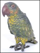 An early 20th century cold painted metal novelty inkwell in the form of a parrot having hinged lid