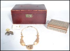 A collection of early 20th century items to include a bone necklace with a central heart shaped