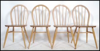 A set of 4 1970's retro hoop back beech and elm wood Ercol light dining chairs. Raised on turned