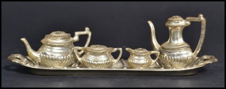 A 20th century miniature silver plated tea service consisting of tea pot, coffee pot, creamer and