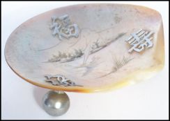 A 19th century Chinese silver and mother of pearl salt / trinket dish raised on three ball feet with