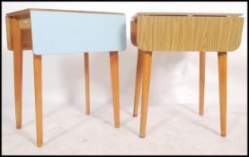 A vintage mid century blue formica drop leaf kitchenette dining table being raised on splayed legs