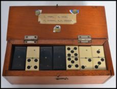A cased set of vintage 20th century ebony and bone dominoes within the original box with plaque to