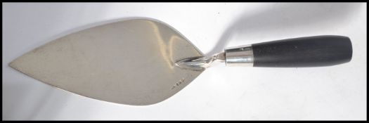 A silver hallmarked presentation trowel having an ebonised handle. Unengraved. Measures 32 cm long.