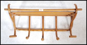 A vintage early 20th century Thonet style wall mounted wooden coat and hack rack with luggage rail