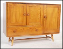 A vintage 20th century retro beech and elm Ercol sideboard raised on tapering legs. Having a