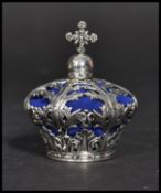 A sterling silver pin cushion in the form of a crown having a scrolled foliage design. Weighs 42