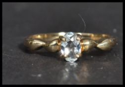 A hallmarked 9ct gold ring having a central  white stone with twist shoulders. Weighs 1.8 grams size