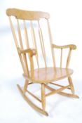 A 20th Century elm and beech Windsor rocking chair with a concave top rail above a rail back over