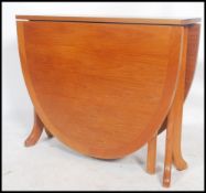 A retro 20th century G-Plan teak drop leaf dining table having shaped supports, the end leaves