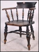 A Victorian beech and elm smokers bow Windsor Elbow chair being raised on turned legs united by