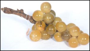 A large ornamental bunch of grapes and vine constructed of large yellow stone balls with wooden