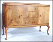 An early 20th century Edwardian walnut sideboard buffet having a central bank of drawers flanked