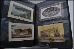 A large album of assorted early 20th Century postcards - including real photo, street scenes, some