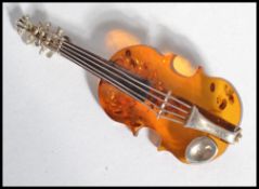 A vintage sterling silver and amber brooch in the form of a violin with pin to verso.