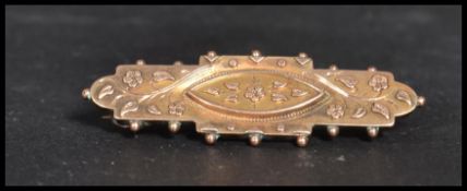 A vintage early 20th century Edwardian hallmarked 9ct gold bar brooch decorated with flowers