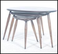 An Ercol beech and elm retro pebble nest of tables, shape 354. Each raised on turned legs having