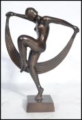 A 20th century Art Deco statue of a nude lady flapper girl dancing with cloth raised on a square